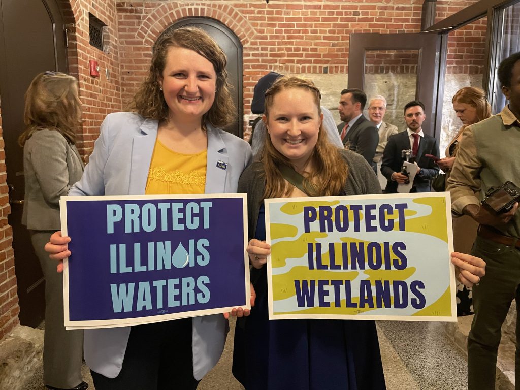 Advocates hold signs that read, "Protect Illinois Waters" and "Protect Illinois Wetlands."